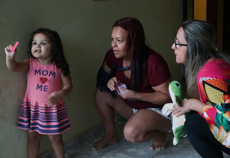 A visitadora Katia Duarte interage com Valentina Nogueira e a mãe, Natalia Gonçalves. (Foto: Clarice Castro/ Secretaria Especial do Desenvolvimento Social)