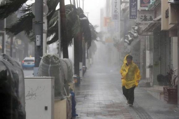 Homem caminha durante chuva forte e ventania causado pelo Tufão Trami em Naha, Okinawa, Japão - 29/09/2018 (Kyodo/Reuters)
