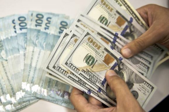 Dólar sobe 0,5% e é negociado a R$ 4,10 para a venda, nesta segunda-feira, 9; bolsa tem alta de 0,2%, aos 103.180 pontos (Vanderlei Almeida/AFP/AFP)