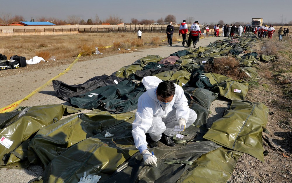 Investigador forense trabalha no local da queda de avião ucraniano no Irã em meio a corpos nesta quarta-feira (8) — Foto: AP Photo/Ebrahim Noroozi